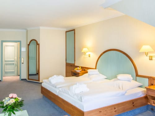 geräumiges Doppelzimmer mit Doppelbett, Wandspiegel und Nachttisch