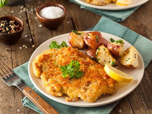 Schweineschnitzel mit Kartoffelspalten und Zitrone