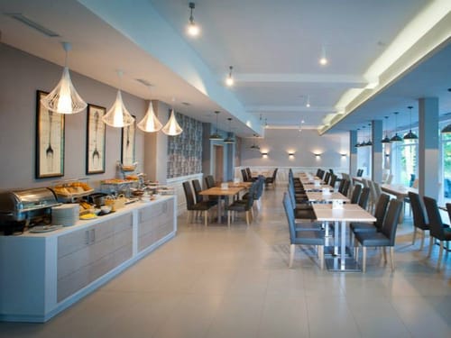 Frühstücksraum mit Speisenbuffet, Tischen und Stühlen