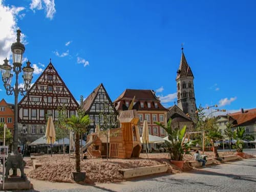 Genießen Sie einen sonnigen Tag im charmanten Fachwerkviertel, das mit einem Sandspielplatz und einer beeindruckenden Kirche lockt. Perfekt für Familien und Geschichtsliebhaber.