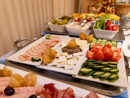 Reichhaltiges Frühstücksbuffet mit Käse, Gemüse und Aufschnitt.