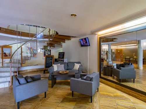 Gemütlicher Hotellobby-Bereich mit grauen Sofas und moderner Einrichtung