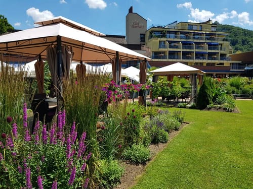 Gartenbereich eines Hotels mit Pavillons und bunten Blumen