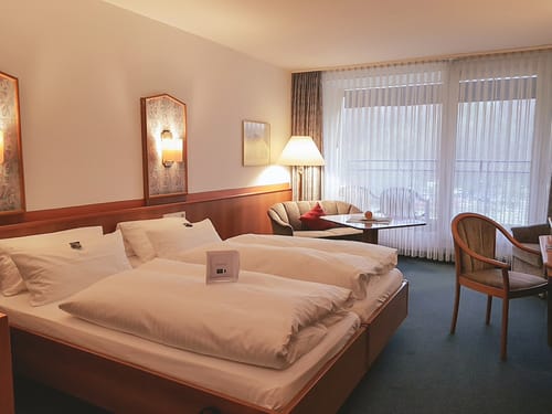schönes Doppelzimmer mit Sitzmöglichkeiten und Schreibtisch