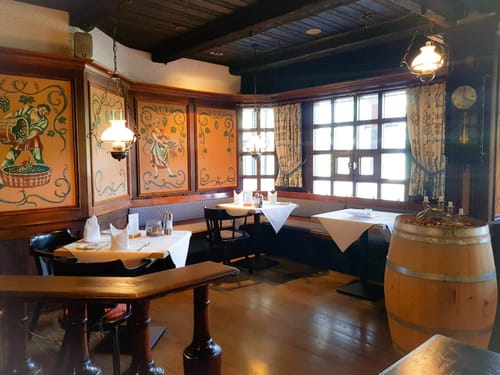 Gemütliches deutsches Restaurant mit rustikalem Interieur und Holzverkleidung