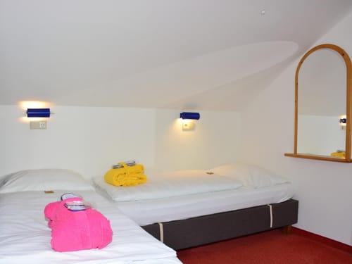 Gemütliches Schlafzimmer mit zwei Einzelbetten und bunten Handtüchern