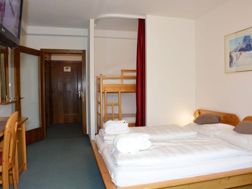 Gemütliches Hotelzimmer mit Doppelbett und Etagenbett