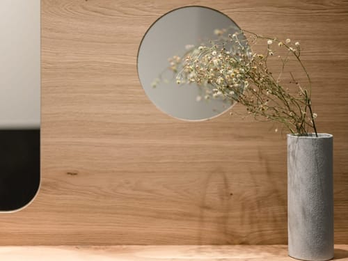 Kleiner Spiegel mit einer Blumenvase davor