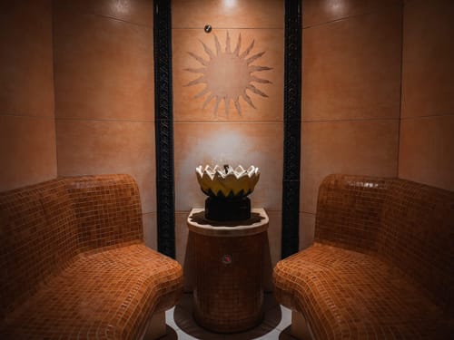 Exklusiver Hamam-Bereich mit handgefertigten Mosaikfliesen-Liegen, Lotusblüten-Brunnen und traditionellem Sonnenmotiv