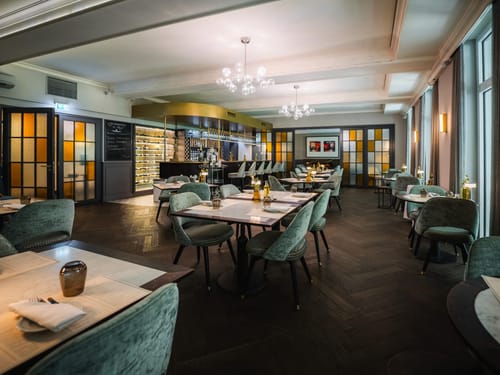 Modernes Restaurantambiente mit elegantem Interieur, weinbestückter Bar und stimmungsvoller Beleuchtung