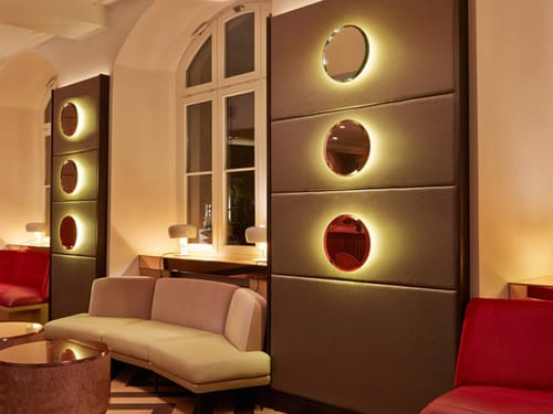 Entdecken Sie das stilvolle Design dieser Hotellounge, das durch moderne Beleuchtungselemente und komfortable Sitzgelegenheiten beeindruckt. Perfekt für eine entspannte Atmosphäre und erholsame Momente.