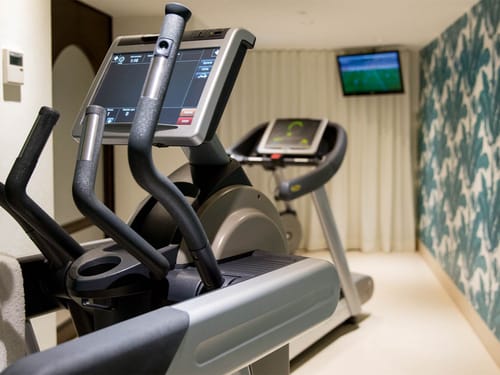 Modernes Fitnessstudio mit Crosstrainer und Laufband.