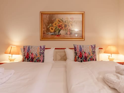 Doppelbett mit Lampen und einem Bild in einem Hotelzimmer