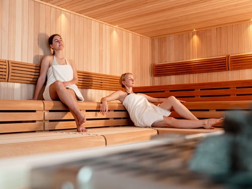 Zwei Frauen in einer Sauna aus Holz