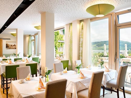 Hotelrestaurant festlich eingedeckt mit weißen Tischdecken