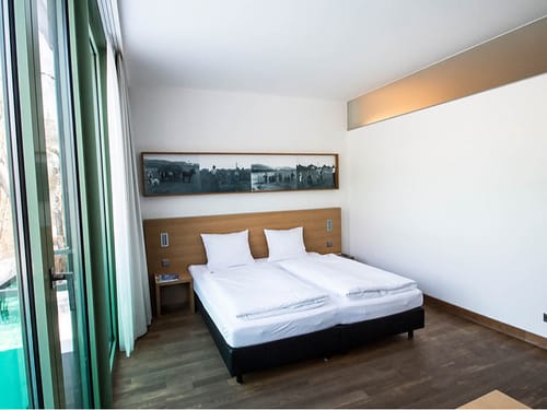 Schlichtes Hotelzimmer mit Doppelbett und Balkon