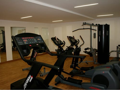 Fitnessraum mit verschiedenen Kardiogeräten und Kraftgeräten
