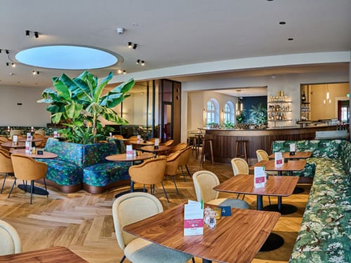 Bar und Loungebreich mit Tischen, Stühlen, Sitzbänke und Barhockern