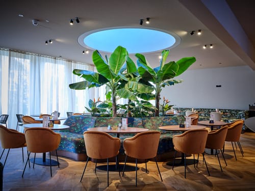 Bar mit kleinen Tischen, Stühlen und Sitzbänken