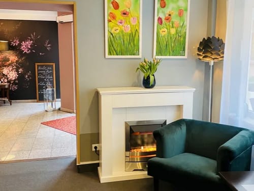 Lobby mit Kamin, Sessel und Dekoartikeln