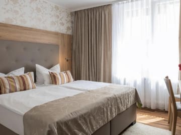 Gemütliches Doppelzimmer mit stilvollem Design und großen Fenstern