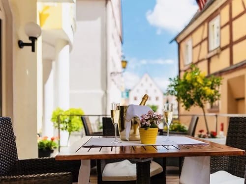 Terrasse mit Tischgruppe, zwei Glas Sekt und Sektkühler