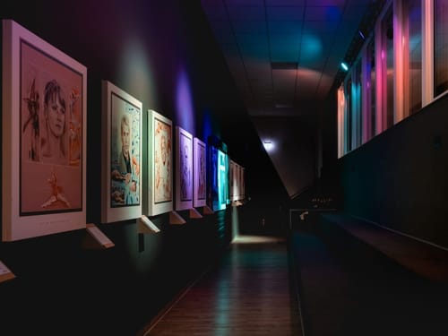 Moderne Kunstausstellung mit Porträts in einem beleuchteten Museum.