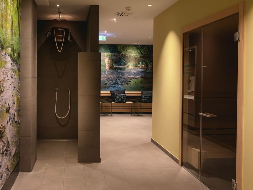 Entspannungsbereich mit Sauna und Regendusche in einem modernen Wellnesscenter.