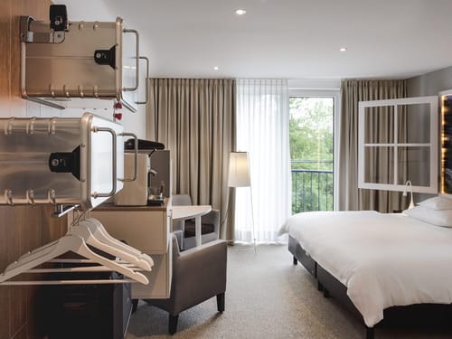 Modernes Hotelzimmer mit Doppelbett und Balkon