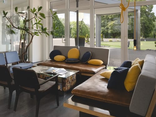 Modernes Lounge-Design mit großen Fenstern und gepolsterten Sitzbereichen.