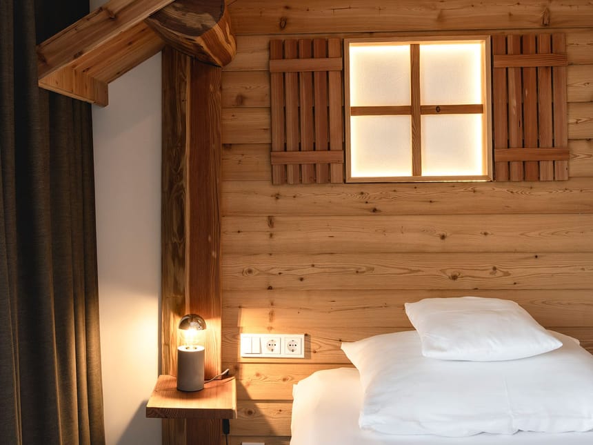 Gemütliches Schlafzimmer mit Holzwand und Beleuchtung