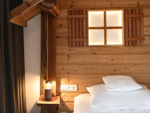 Gemütliches Schlafzimmer mit Holzwand und Beleuchtung