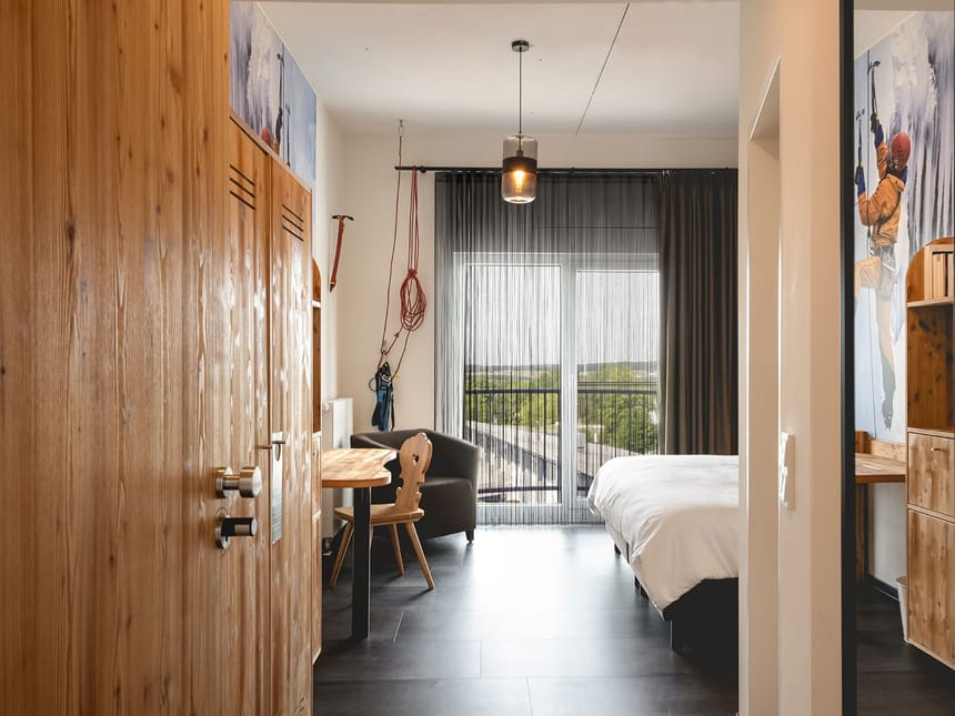 Modernes Hotelzimmer mit Kletterthema und Holzelementen.