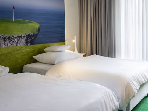 Modernes Hotelzimmer mit Golf-Dekor und zwei Einzelbetten