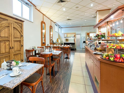 eingedeckte Tisch und Frühstücksbuffet