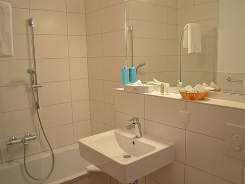 Badbereich mit Wanne, Waschtisch und großem Wandspiegel