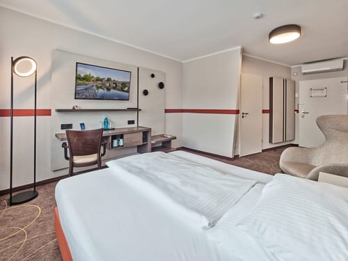 Modernes Hotelzimmer mit Doppelbett, Schreibtisch und Fernseher