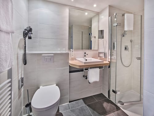 Modernes Badezimmer mit Dusche und weißen Fliesen