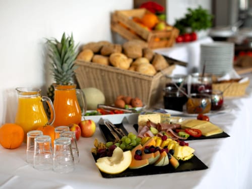 Frühstücksbuffet mit Säften, Obst, Marmeladen und verschiedene Backwaren