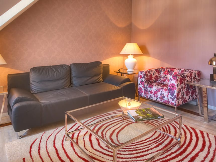 Leder und Stoffcouch mit Tischen und Leselampe