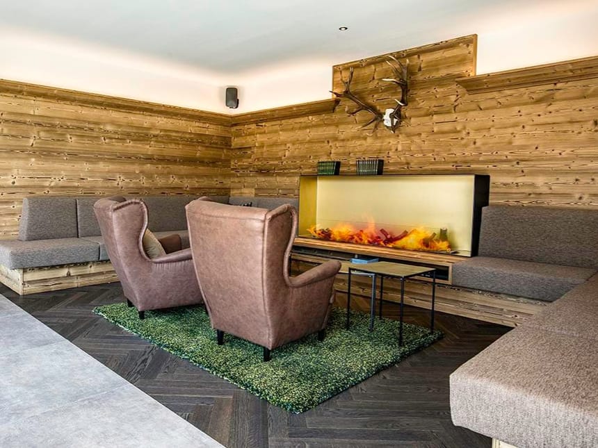 verschiedene Sessel und eine große Sitzbank im Loungebereich