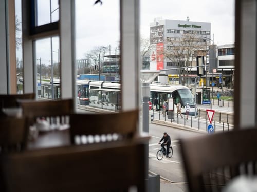 Tische, Stühle und eine Straßenbahn