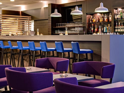 moderne Hotelbar mit blau bezogenen Barhockern