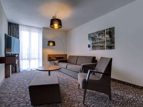 TV, Sofa, Sessel und Tisch im Doppelzimmer