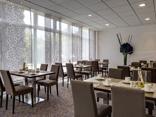eingedeckte Tische im Frühstücksraum