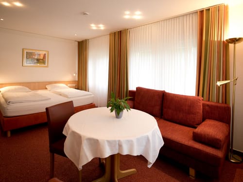 Doppelbett, Sessel, Couch, Tisch und Stehlampe