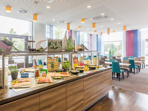 Buffetinsel mit verschiedenen Köstlichkeiten sowie einige Tischgruppen