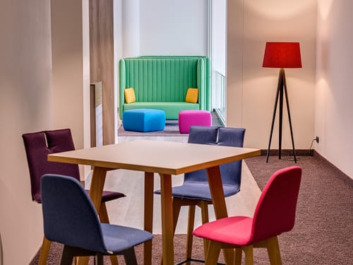 Tischgruppe mit vier Stühlen und ein grünes Sofa
