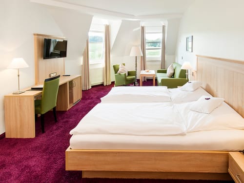 Modernes Doppelzimmer mit Doppelbett und Sitzecke