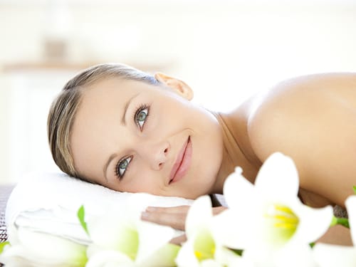 Eine Frau liegt auf einem Handtuch mit Blumen im Vordergrund